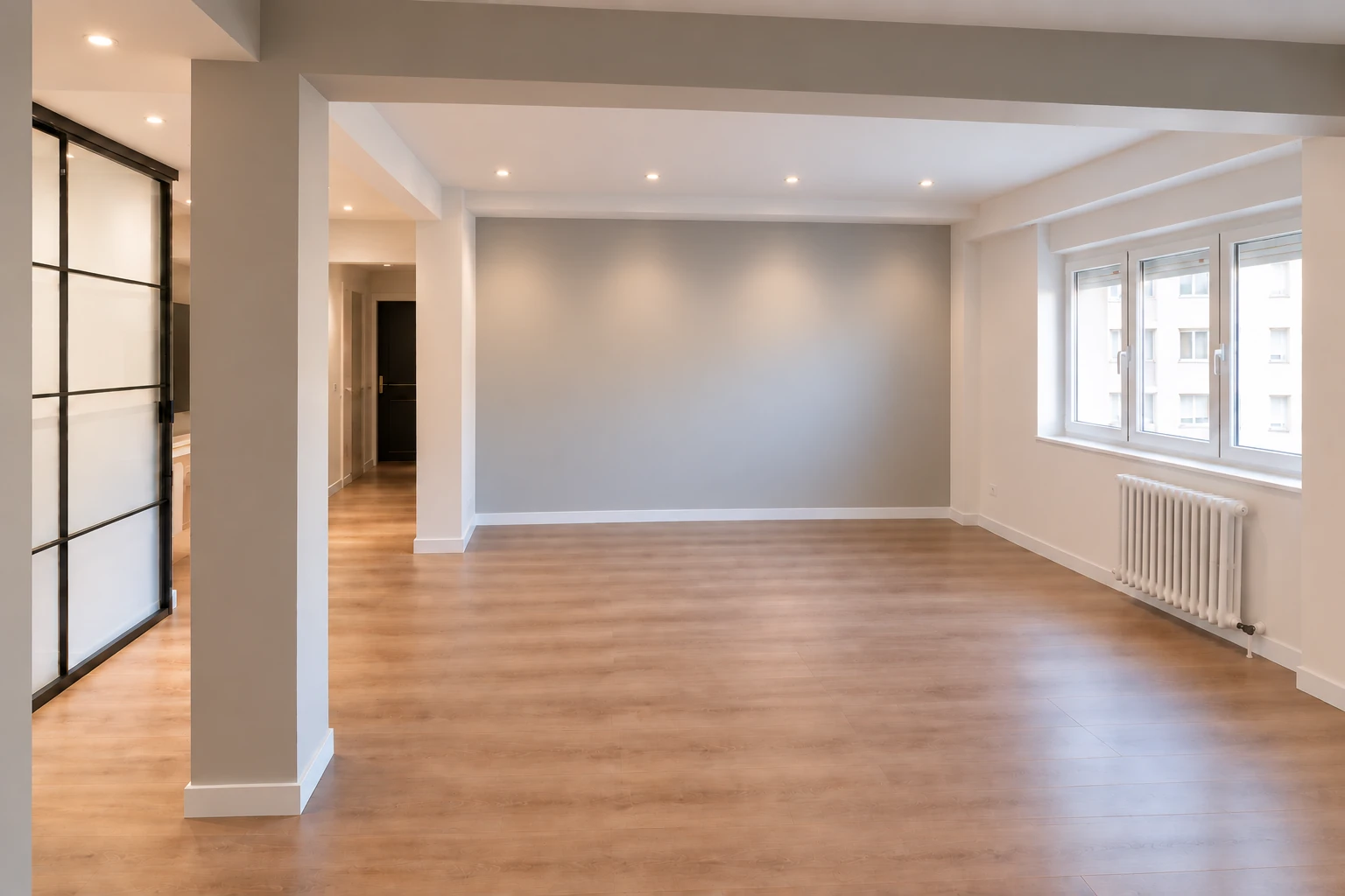 Salón despejado con suelo de madera y cerramiento acristalado; imagen adaptada para inspiración
